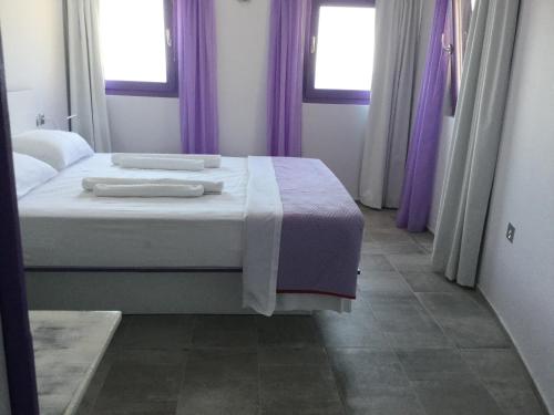 a bedroom with a large bed with purple curtains at Apartment at KiVA-villa, Kampi, KEA, Cyclades, Greece in Ligia