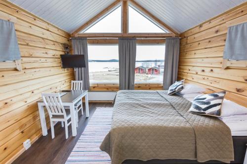 Schlafzimmer mit einem Bett, einem Schreibtisch und einem Fenster in der Unterkunft Holiday Village Inari in Inari