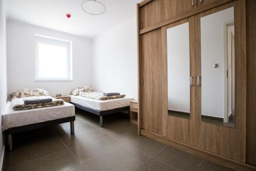 ベケスゼンタンドラスにあるFüzeskerti Apartmanházのベッド2台と鏡が備わる客室です。