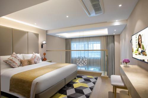 a bedroom with a large bed and a window at Citadines Keqiao Shaoxing in Shaoxing