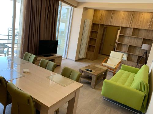 a living room with a table and green chairs at Gonio N904 Beachfront Panorama in Gonio