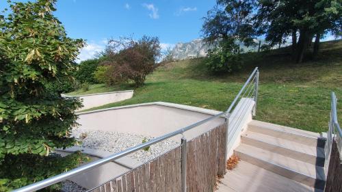 a set of stairs with a fence next to a yard at Gîte clair, spacieux et cosy avec vue sur le massif de la Chartreuse in Sainte-Hélène-du-Lac