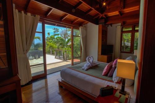 a bedroom with a bed and a large window at Luxury 4 bedrooms Villa with Seaview Infinity Pool overlooking Surin Beach in Surin Beach