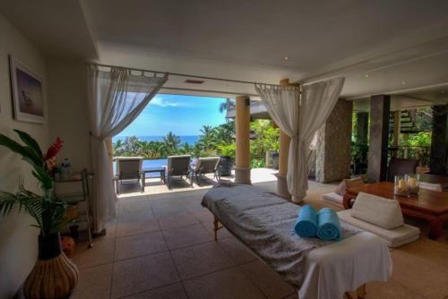 a bedroom with a bed and a living room with a view at Luxury 4 bedrooms Villa with Seaview Infinity Pool overlooking Surin Beach in Surin Beach