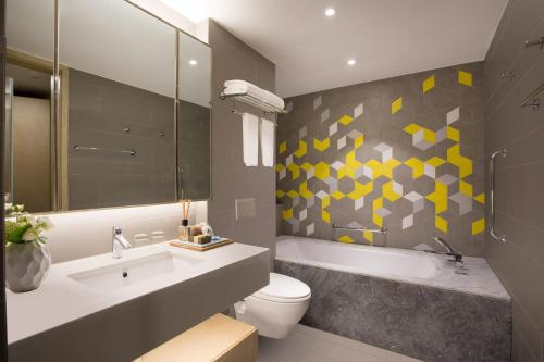 a bathroom with a sink and a toilet and a tub at Citadines Keqiao Shaoxing in Shaoxing