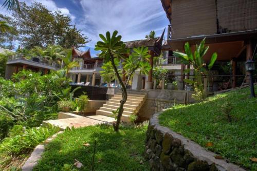 a house with stairs in front of a house at Luxury 4 bedrooms Villa with Seaview Infinity Pool overlooking Surin Beach in Surin Beach