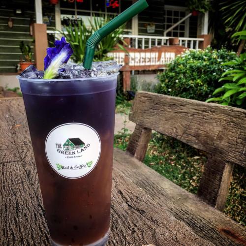 a drink is sitting on a wooden table at The Green land (Khok Kruat) in Nakhon Ratchasima