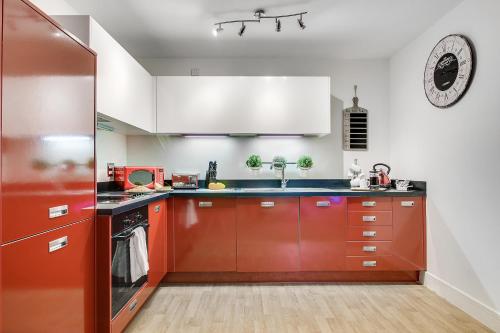 a kitchen with red cabinets and a sink at The President in Birmingham