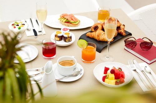 a table with plates of breakfast foods and drinks at Migjorn Ibiza Suites & Spa in Playa d'en Bossa
