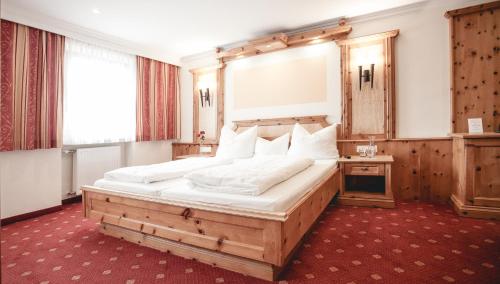 a bedroom with a large bed with a wooden frame at Gasthof Schmalzerhof in Weer