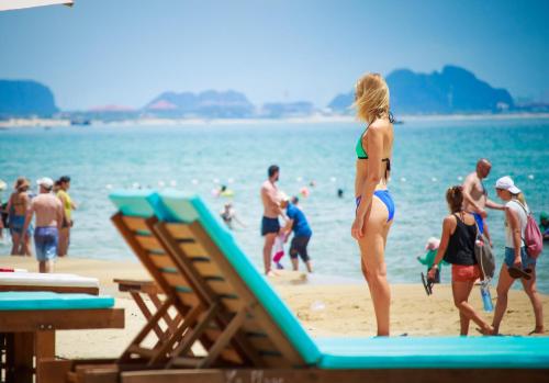 a woman in a bikini standing on a beach at Hoi An Sea Village Homestay in Hoi An