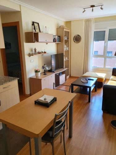 - un salon avec une table et un canapé dans l'établissement Acogedor Apartamento en Oviedo Frente al HUCA, à Oviedo