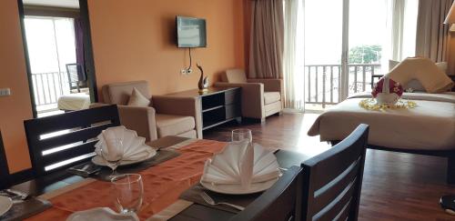 a hotel room with a bed and a living room at Sarita Chalet & Spa Hotel - SHA Extra Plus in Jomtien Beach