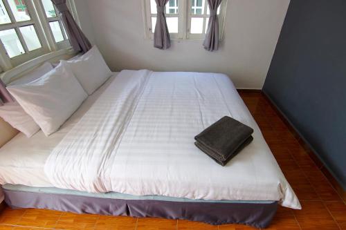 a large white bed with a brown bag on it at Vagary Pangkor in Pangkor