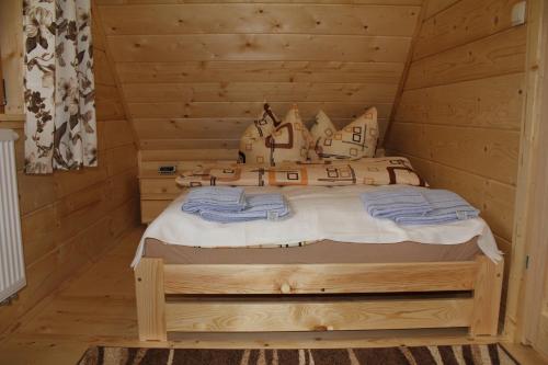 a bedroom with a bed in a log cabin at Marang Domki i Apartamenty in Szczyrk