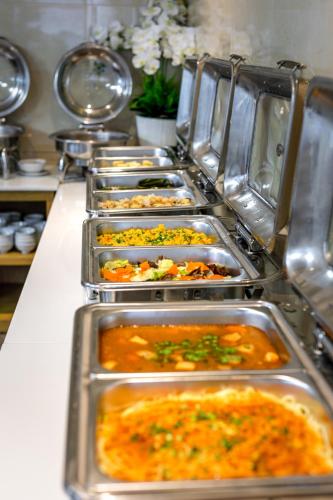 un buffet avec de nombreux plateaux de nourriture dans l'établissement Greenery Hotel, à Đà Nẵng