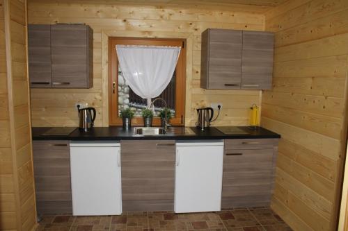a kitchen with a counter and a window at Marang Domki i Apartamenty in Szczyrk