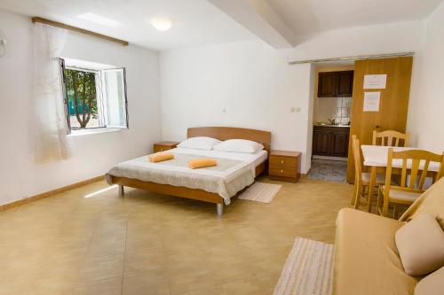 a bedroom with a bed and a table and a kitchen at Villa Ivanka in Korčula