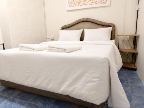 a large white bed with white sheets and pillows at NB House in Karon Beach