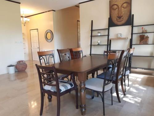 a dining room with a wooden table and chairs at บ้านนกเคียงจัน ปากช่อง Nok Kiang Chan Home Pak Chong in Ban Nong Ka Cha