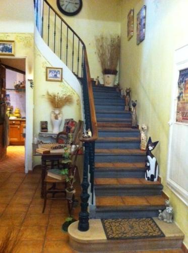 a staircase in a house with a clock on the wall at Chez Mimi & Chouchou in Garéoult
