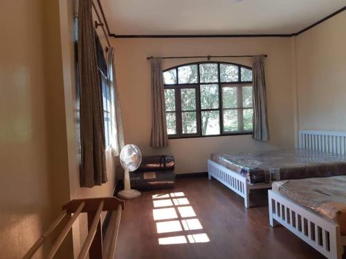 a bedroom with two beds and a window at บ้านนกเคียงจัน ปากช่อง Nok Kiang Chan Home Pak Chong in Ban Nong Ka Cha