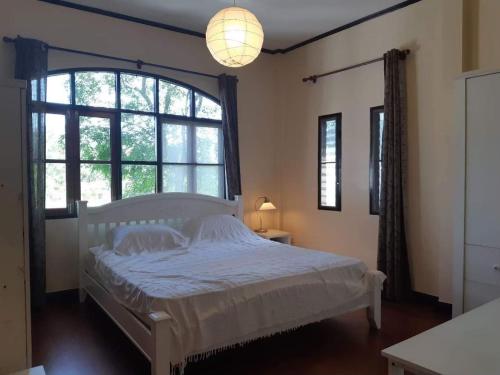 a bedroom with a bed and a large window at บ้านนกเคียงจัน ปากช่อง Nok Kiang Chan Home Pak Chong in Ban Nong Ka Cha