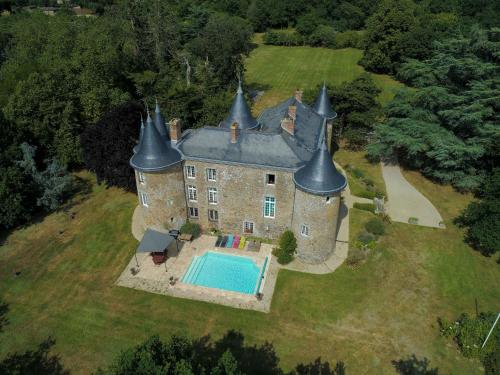 un vieux château avec une piscine en face dans l'établissement Château De La Frogerie, à Maulévrier