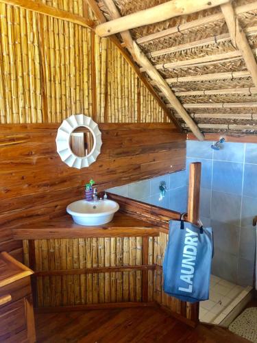 a bathroom with a sink and a mirror at Pura Vida Lodge in Morrumbene