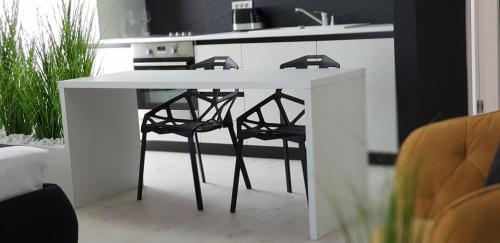a kitchen with a white table and stools at WEST RESIDENCE APARTMENTS in Timişoara