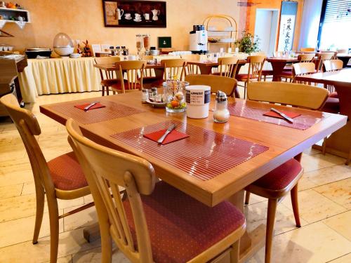 a wooden table and chairs in a restaurant at Hotel Fantasie in Ansbach