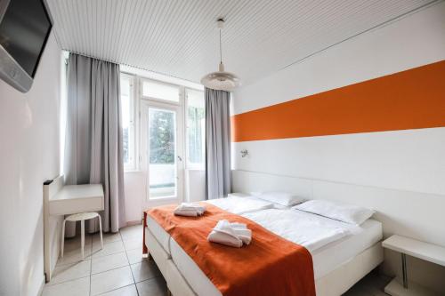 - une chambre avec un lit et 2 serviettes dans l'établissement Hotel Holiday Csopak, à Csopak