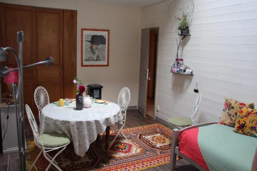 une salle à manger avec une table, des chaises et un canapé dans l'établissement Les Ateliers d'Art Modiste et formier, à Roanne