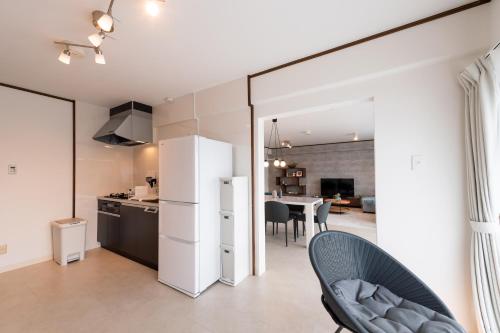 a kitchen and dining room with a white refrigerator at Little Santa in Ginowan
