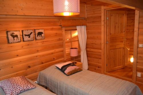 a bedroom with two beds in a log cabin at Chalet Suomukka in Suomutunturi