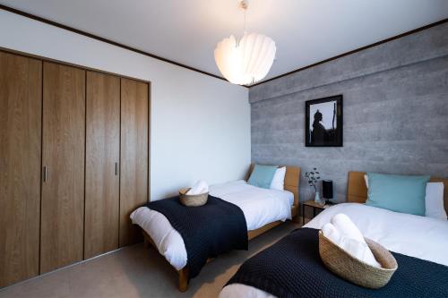 a bedroom with two beds and a wall at Little Santa in Ginowan