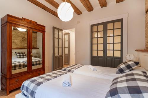 1 dormitorio con 2 camas y armario de madera en El Roblón de la Estafeta, en Pamplona