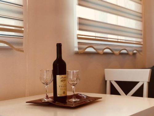 een fles wijn en twee glazen op een tafel bij Laguna apartment in Tivat