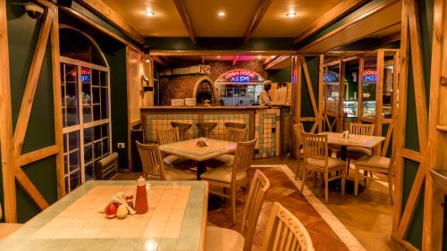 a restaurant with tables and chairs in a room at Hotel Nahar Nilgiris in Ooty