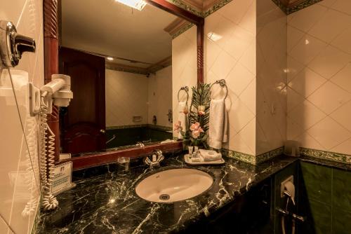 a bathroom with a sink and a large mirror at Hotel Nahar Nilgiris in Ooty