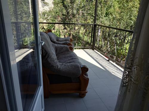 two people sitting on a chair on a balcony at Nino's Holiday guesthouse in Borjomi