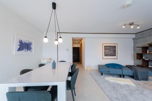 a kitchen and living room with a white table and chairs at Little Santa in Ginowan