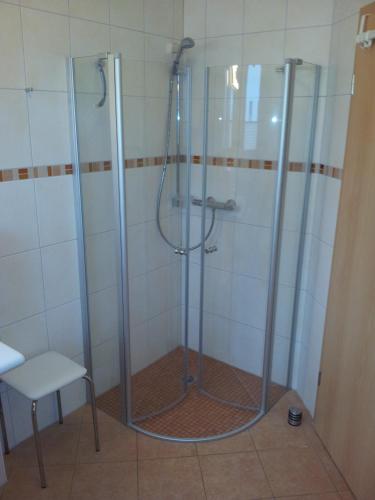 een badkamer met een douche met een kruk en een stoel bij Meeresbrise Asternweg in Zinnowitz