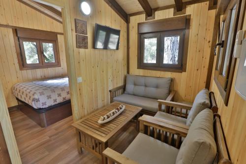 a small room with a couch and a bed at Complejo Residencial Los Enebros in Arroyo Frio