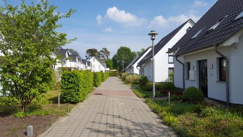 een bakstenen stoep in een woonwijk met witte huizen bij Meeresbrise Asternweg in Zinnowitz