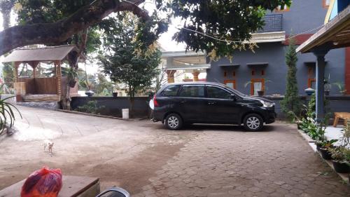 a black car parked in front of a house at Budhis Home in Bromo