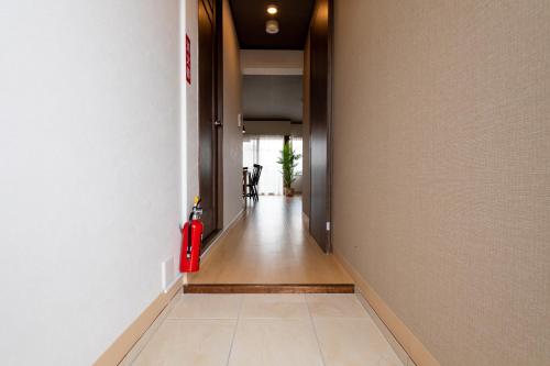 a hallway with a red fire hydrant on the side of a building at Little Santa in Ginowan