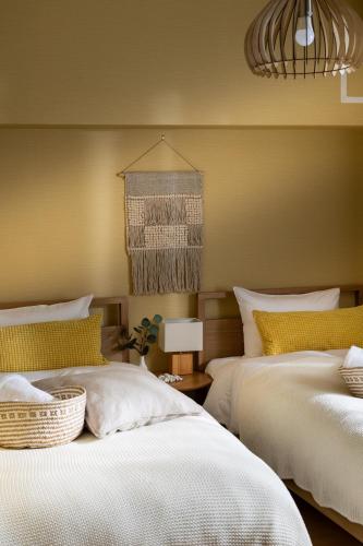 two beds sitting next to each other in a bedroom at Little Santa in Ginowan