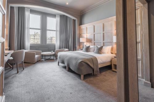 a hotel room with a bed and a desk and a window at The Scotsman Hotel in Edinburgh