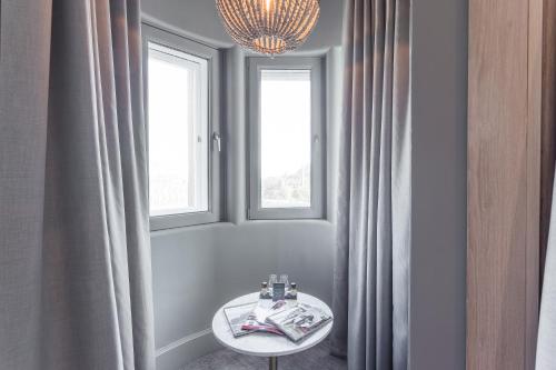 a room with a table and two windows at The Scotsman Hotel in Edinburgh
